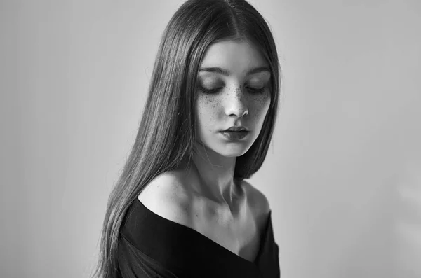 そばかすスタジオ撮影で白い背景で隔離のある美しい孤独な少女の劇的な黒と白の肖像 — ストック写真