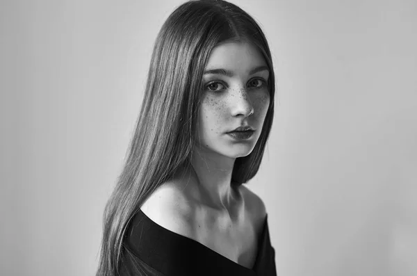 Dramatiska svartvita porträtt av en vacker ensam flicka med fräknar isolerad på en vit bakgrund i studio skott — Stockfoto