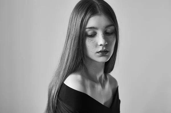 Dramático retrato preto e branco de uma bela menina solitária com sardas isoladas em um fundo branco em estúdio tiro — Fotografia de Stock