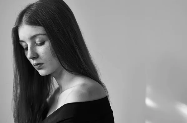 Retrato dramático en blanco y negro de una hermosa chica solitaria con pecas aisladas sobre un fondo blanco en una toma de estudio —  Fotos de Stock