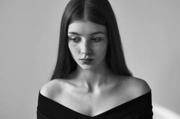 Dramático retrato preto e branco de uma bela menina solitária com sardas isoladas em um fundo branco em estúdio tiro — Fotografia de Stock