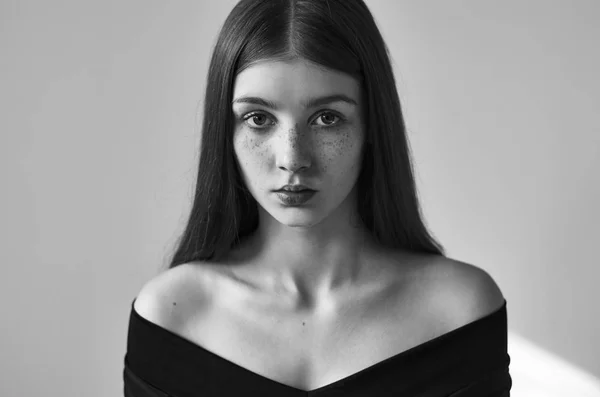 Dramatiska svartvita porträtt av en vacker ensam flicka med fräknar isolerad på en vit bakgrund i studio skott — Stockfoto