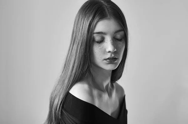 Dramático retrato preto e branco de uma bela menina solitária com sardas isoladas em um fundo branco em estúdio tiro — Fotografia de Stock