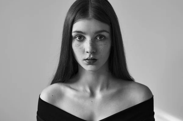 Retrato dramático en blanco y negro de una hermosa chica solitaria con pecas aisladas sobre un fondo blanco en una toma de estudio — Foto de Stock