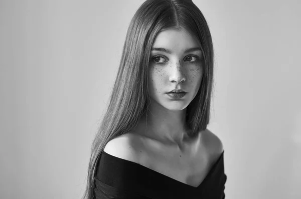 Retrato dramático en blanco y negro de una hermosa chica solitaria con pecas aisladas sobre un fondo blanco en una toma de estudio —  Fotos de Stock