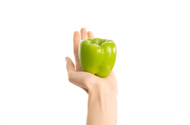 Sağlıklı beslenme ve diyet Konu: Studio, birinci şahıs bakış beyaz bir arka plan üzerinde izole bir yeşil biber tutan eller