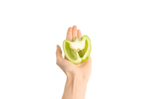Gezonde voeding en dieet onderwerp: menselijke hand met halve groene paprika geïsoleerd op een witte achtergrond in de studio, first person view — Stockfoto