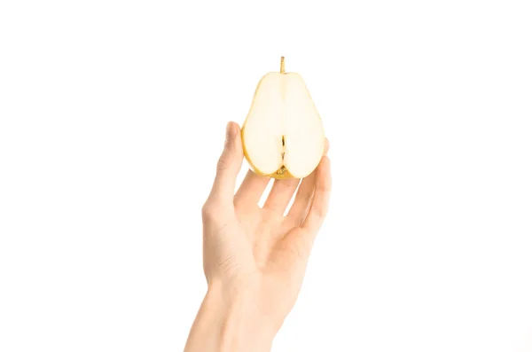 Тема: Human hand holds half of pear isolated on a white background in the studio, first-person view — стоковое фото