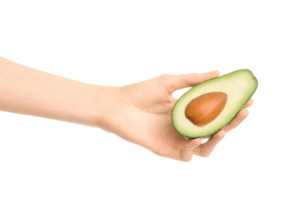 Gezonde voeding en dieet onderwerp: menselijke hand met een halve avocado geïsoleerd op een witte achtergrond in de studio — Stockfoto