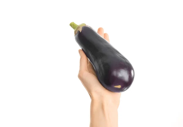 Gezonde voeding en dieet onderwerp: menselijke hand met een rijpe aubergines geïsoleerd op een witte achtergrond in de studio, first person view — Stockfoto