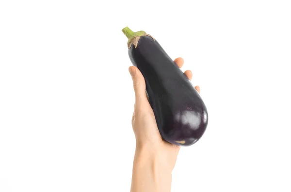 Gezonde voeding en dieet onderwerp: menselijke hand met een rijpe aubergines geïsoleerd op een witte achtergrond in de studio, first person view — Stockfoto