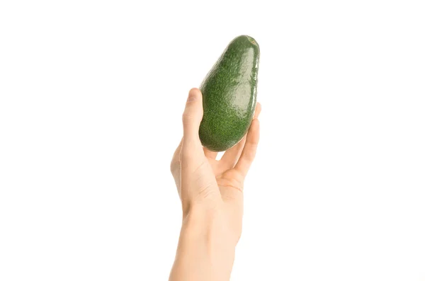 Gezonde voeding en dieet onderwerp: menselijke hand met een rijpe avocado geïsoleerd op een witte achtergrond in de studio, first person view — Stockfoto