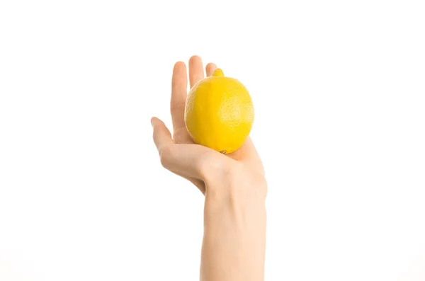 Healthy eating and diet Topic: Human hand holding yellow lemon isolated on a white background in the studio, first-person view — Stock Photo, Image