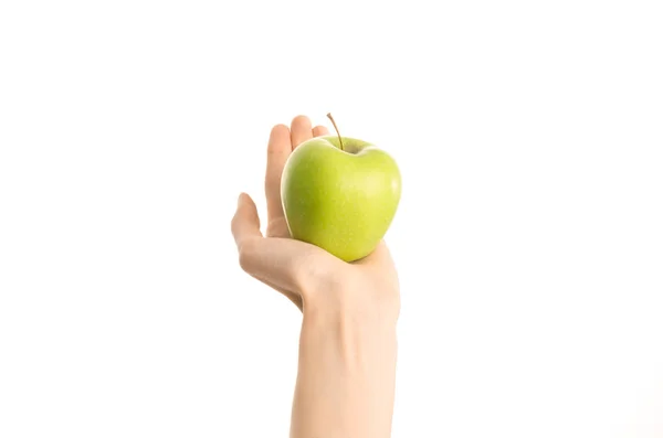 Thème : Main humaine tenant une pomme verte isolée sur un fond blanc en studio, vue à la première personne — Photo