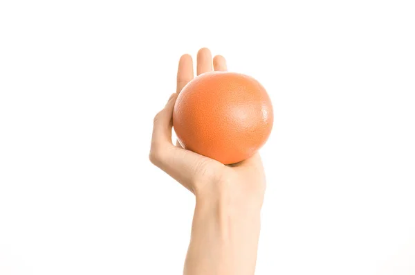 Tópico de alimentação e dieta saudável: mão humana segurando uma toranja vermelha isolada em um fundo branco no estúdio, visão em primeira pessoa — Fotografia de Stock