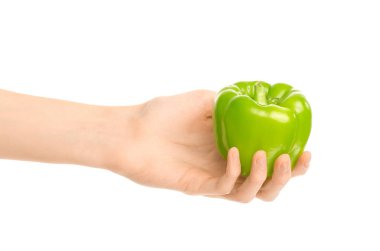 Sağlıklı beslenme ve diyet Konu: beyaz bir arka planda stüdyoda izole bir yeşil biber tutan eller