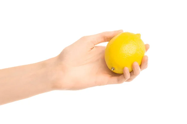 Thème : Main humaine tenant le citron jaune isolé sur un fond blanc en studio — Photo