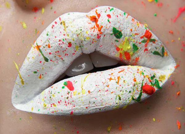 Macro en close-up creatieve make-up thema: mooie dikke lippen met witte verf en gekleurde sprays — Stockfoto