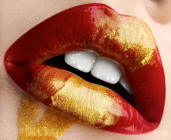 Tema tata rias kreatif makro dan close-up: Cantik bibir perempuan gemuk dengan cat merah dan emas, efek basah pada bibir — Stok Foto