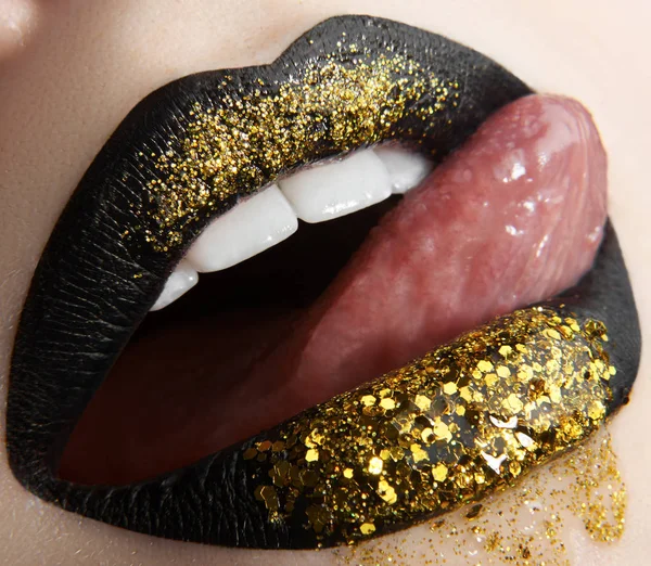 Macro en close-up creatieve make-up thema: mooie vrouwelijke lippen zwarte lippenstift en goud pailletten, geretoucheerde foto — Stockfoto