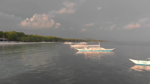 Prázdné vyhlídkové čluny stojí u písečného břehu při západu slunce. Filmový pohled zblízka. — Stock video