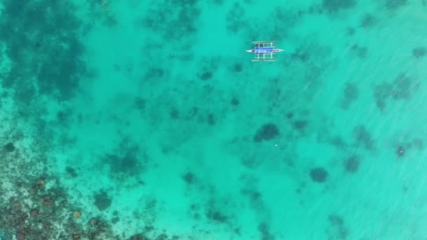 Αεροφωτογραφία ενός μοναχικού σκάφους σε μια γαλαζοπράσινη διάφανη θάλασσα με κοραλλιογενείς υφάλους και ένα βαθύ μπλε κοίλο — Αρχείο Βίντεο