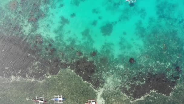 Vista aérea de los barcos de pesca en un mar turquesa transparente con arrecifes de coral y un hueco azul profundo — Vídeos de Stock