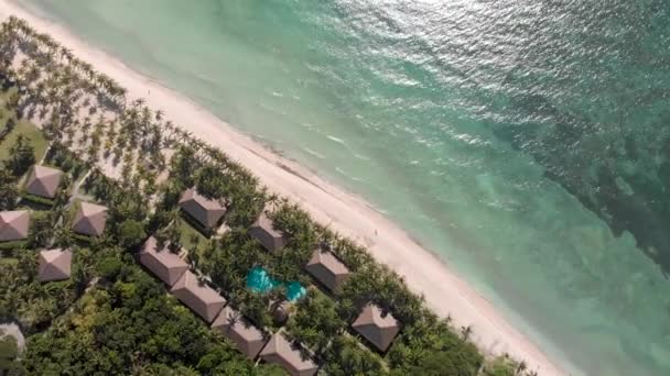 Vista panorámica aérea de las olas del mar, palmeras verdes, hoteles, casas y resorts en la playa de arena . — Vídeo de stock
