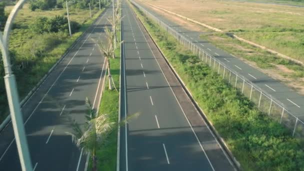 Κινηματογραφικό drone πλάνο του δρόμου με φοίνικες και αυτοκίνητο ιππασίας. Βόλτα με αυτοκίνητο και μοτοσικλέτα στον αυτοκινητόδρομο — Αρχείο Βίντεο