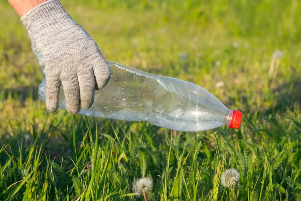 stock image Volunteer cleaning up the garbage. A gloved hand cleans plastic bottles from a clearing. Ecology. Pure nature. Separate garbage collection. Stop plastic. Recycling. Zero waste.