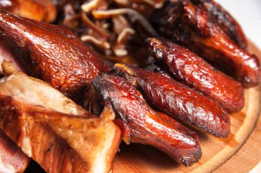 Tütsülenmiş Buffalo Wings. Yakın plan. İştah açıcı bir şekilde diğer et lezzetlerinin yanında bir tepside yatıyor.