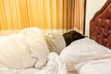 Sabahleyin yatakta uyuyan kadın.