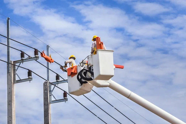 Electricistas reparando alambre de la línea eléctrica con cubo plataforma de elevación hidráulica — Foto de Stock
