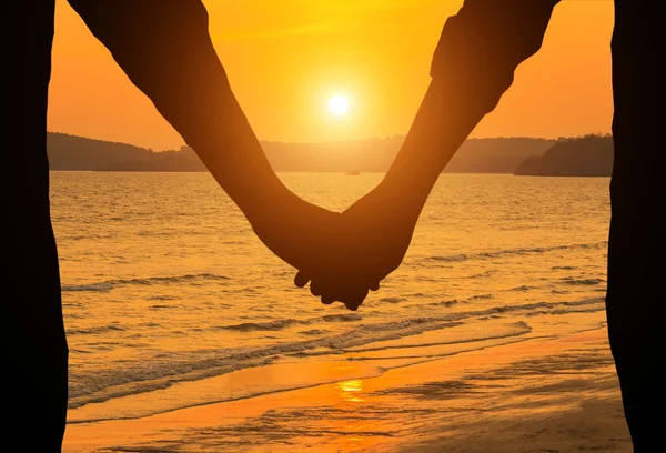 剪影夫妇手牵手在热带的海滩上在日落 — 图库照片