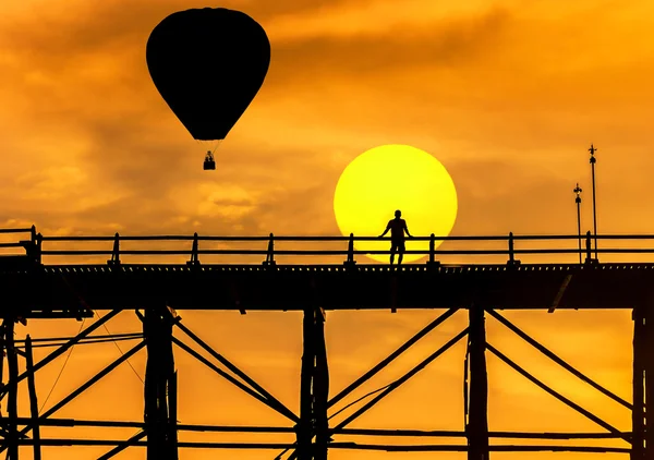 Silhouette hot air balloons floating over old wooden bridge in thailand on sunset — Stock Photo, Image