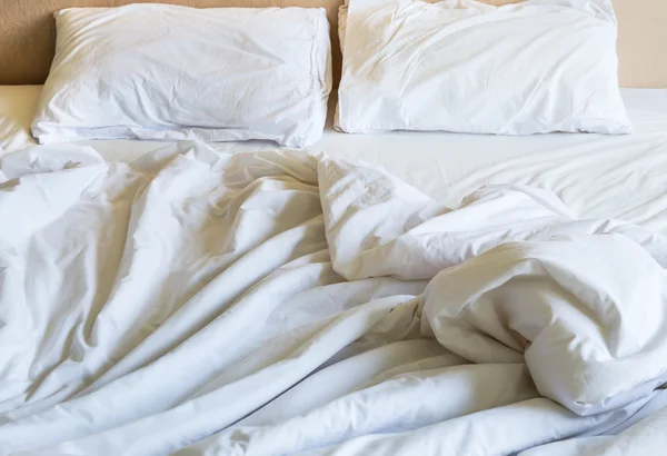 Messy white bed sheets in the morning. — Stockfoto