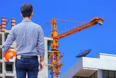 vinç ile şantiye binada sarı kask tutan mühendisi 