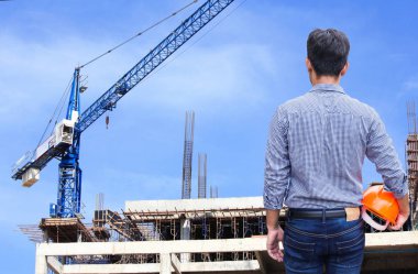 Şantiye binada sarı kask tutan mühendisi