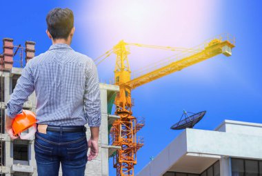 vinç ile şantiye binada sarı kask tutan mühendisi