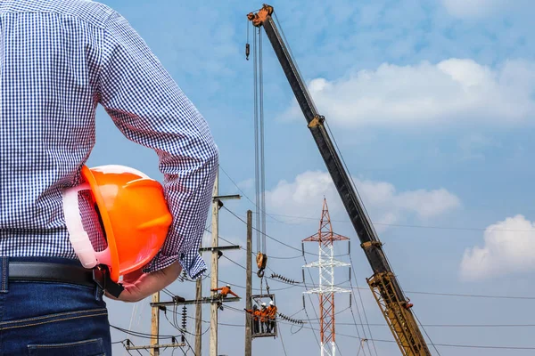 Inżynier, trzymając żółty kask w budynku Plac budowy z dźwigiem — Zdjęcie stockowe