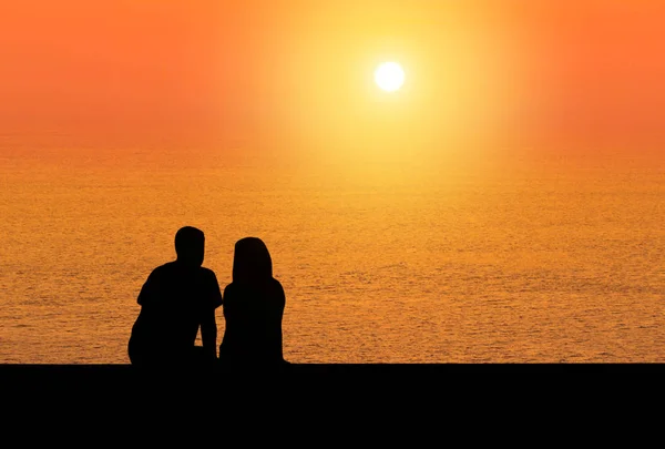 Silhoutte vista trasera romántica pareja sentarse relajarse viendo atardecer — Foto de Stock