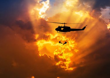 siluet asker eylem rappelling, helikopterden günbatımı arka plan üzerinde aşağı in 
