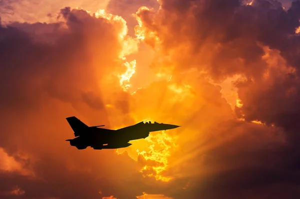 Silhueta caça avião a jato voando ao pôr do sol — Fotografia de Stock