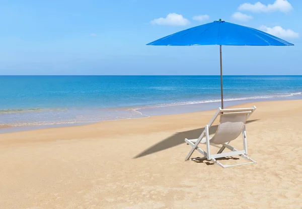 Cadeira de praia de madeira branca vazia e guarda-sol azul na praia tropical — Fotografia de Stock