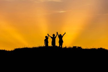 küçük kaldırdı çocukla küçük kız ayakta eller yukarı sunset bulvarında siluet. 