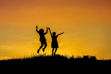 Siluet çocuklar için gökyüzü günbatımı üzerinde atlama   