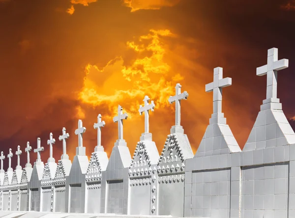 Witte kruisen op de begraafplaats van de kerkhof op zonsondergang — Stockfoto
