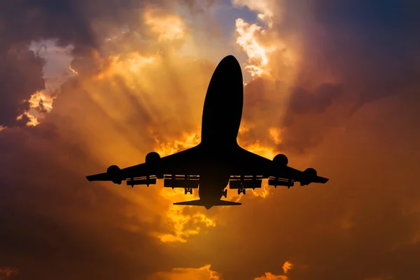 Avión de pasajeros de silueta volando al cielo al atardecer — Foto de Stock