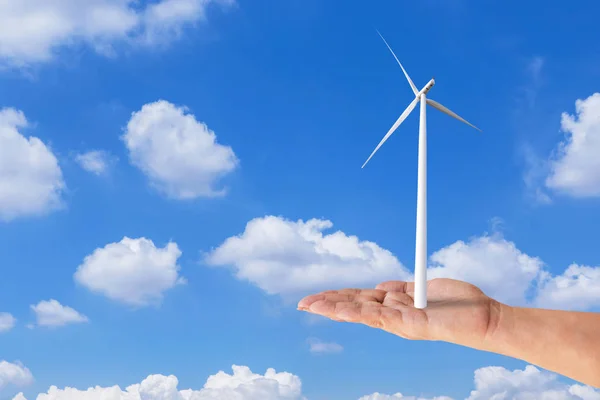 Woman hand holding wind turbine on blue sky — Stock Photo, Image