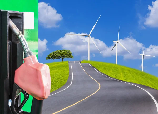 Fuel nozzle service station with empty asphalt road  and wind turbines on green field — Stock Photo, Image